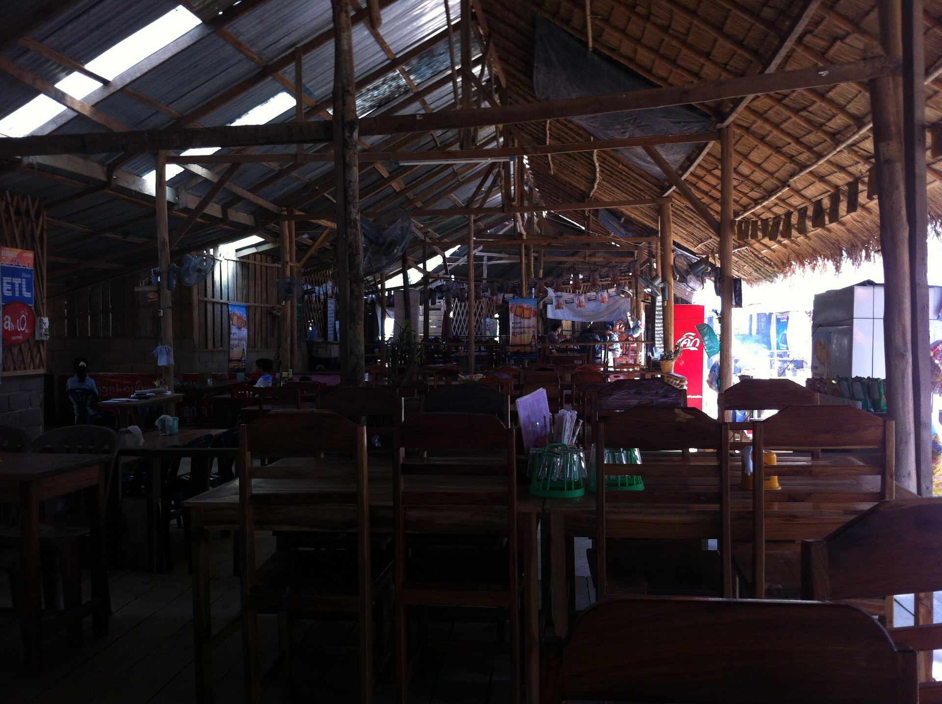 An empty wooden village restaurant with thatched roof in rural Laos